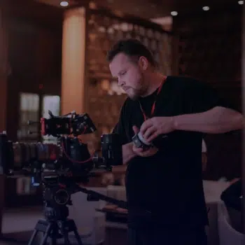 Persona trabaja con una cámara profesional de cine en un set interior con iluminación artificial