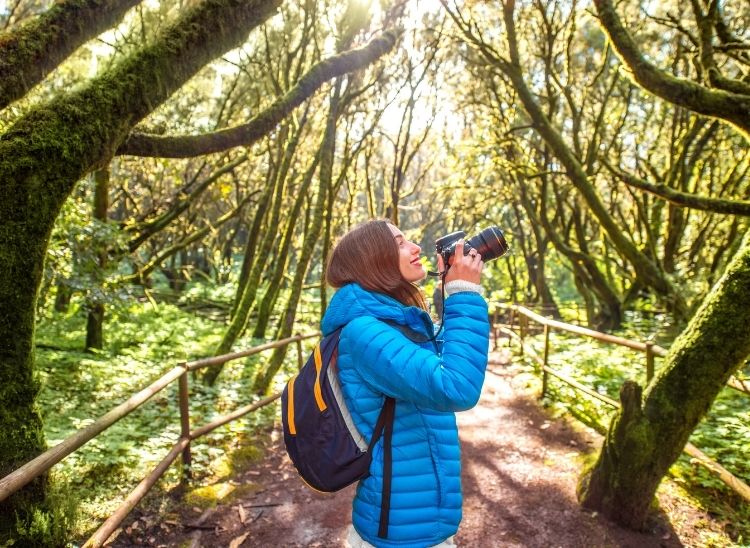 fotógrafa de naturaleza tomando fotos en el exterior con cámara profesional