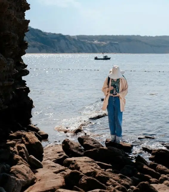 En la imagen, una mujer hace una fotografía junto al mar