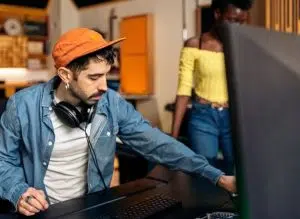 Técnico de sonido sentado frente a un ordenador con cascos